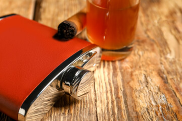 New hip flask on wooden background, closeup