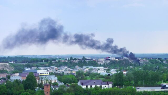 Black smoke rises over industrial zone. Pollution concept.