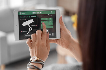 Young woman using smart home security system control panel, closeup