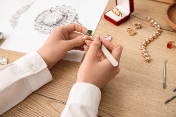 Female jeweler making ring on wooden table, closeup - obrazy, fototapety, plakaty