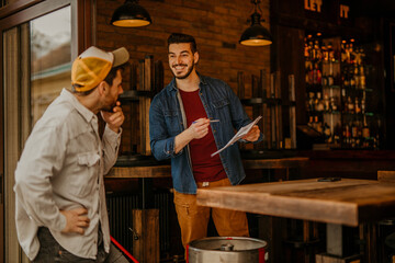 The cafe owner talking to a delivery worker and signed the paperwork.
