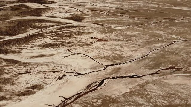 dry river of Death Valley National Park from above shot by drone show Badwater Basin - this dry salt lake flat is the most popular attraction in the park with desert valley around