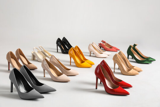 Many different stylish high heels on grey background