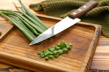 Board with fresh cut green onion on table