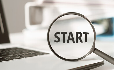 The word START on a magnifying glass in the office. Business concept search start