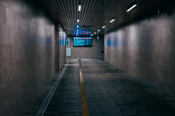 Empty underground passage under the highway. Gray illuminated underground passage without people....