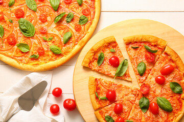 Board with tasty pizzas margarita on white wooden background