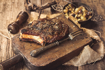 côte de boeuf entière sur un billot avec sa fourchette à viande; photo réelle