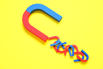 Horseshoe shaped magnets on yellow background