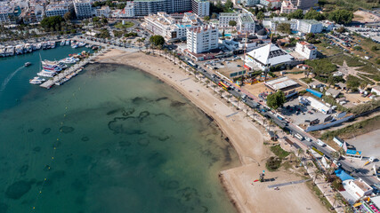 Fototapeta na wymiar Aerial drone photo of a beach in the town of Sant Antoni de Portmany on the island of Ibiza in the Balearic Islands Spain showing the boating harbour and the beach known as Playa de San Antonio