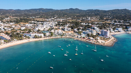 Aerial drone photo of the town of Sant Antoni de Portmany on the west coast of Ibiza Spain’s Balearic Islands, showing the ocean front and Calo des Moro beach with boats in the ocean