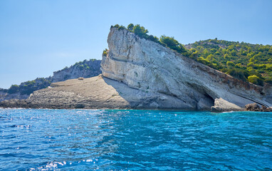 Rejs łodzią w pobliżu wyspy Zakynthos w słoneczny dzień z widokiem na skaliste wybierze