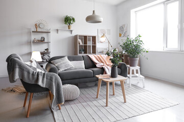 Interior of living room with glowing lamps, sofa and armchair
