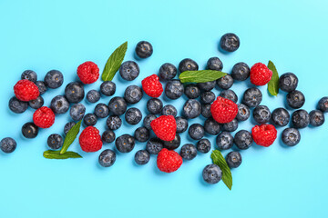 Fresh blueberries and raspberries on blue background