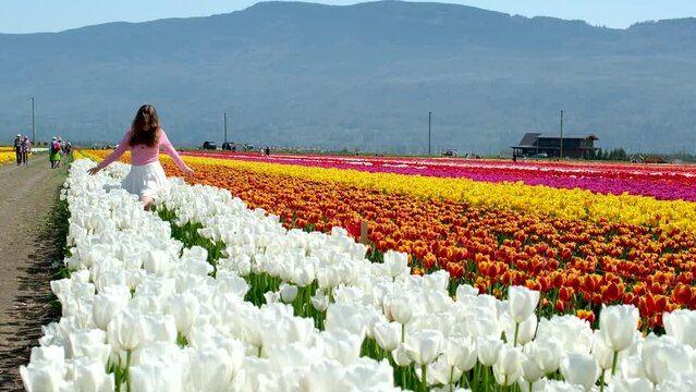 a young girl walks on a white field dancing in white tennis skirt tenderness virginity beauty against the background of mountains Youth walk in nature in spring