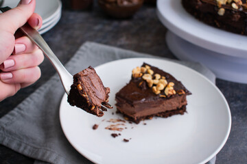 Piece of Chocolate Hazelnut Mousse Cake on a Fork: Dark chocolate and hazelnut mousse pie on a white plate with a fork