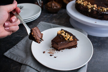 Piece of Chocolate Hazelnut Mousse Cake on a Fork: Dark chocolate and hazelnut mousse pie on a white plate with a fork