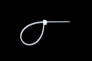 White plastic cable ties isolated on black background. plastic wire ties close up.