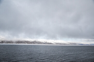 Low clouds over the mountains surrounding Lake Sevan on autumn day. Popular Armenian touristic destination.