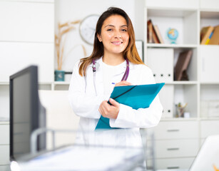 Smiling young female therapist fills out an appointment sheet on a tablet in the office at the...