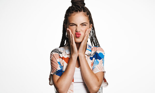 Beauty and makeup. Sassy modern woman, has bright red listick, squeezes her cheeks, grimacing, makes funny faces, stands over white studio background