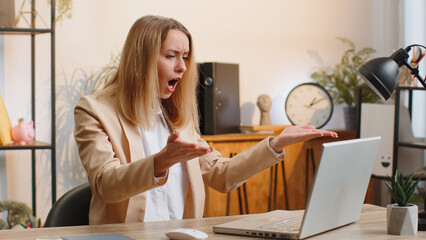 Young businesswoman programmer software developer working on laptop loses becoming surprised by bad...