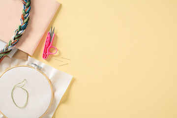 Needlework concept. Embroidery hoop and accessories on color background. Flat lay, top view.