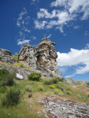 face-shaped mountainside rock in the mountains of South America against a backdrop of blue sky with cirrus clouds