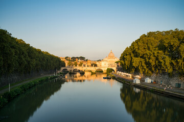 Fototapeta premium St. Peter's basilica and St. Angelo bridge seen across Tiber river canal in Rome. Italy