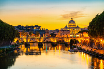 St. Peter's basilica across Tiber River canal at sunset in Rome, Italy