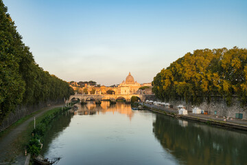 Fototapeta na wymiar St. Peter's basilica and St. Angelo bridge seen across Tiber river canal in Rome. Italy