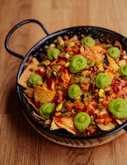 Plato de nachos con carne, queso y guacamole