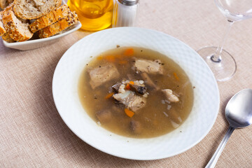 Fototapeta Pork soup with mushrooms cooked with pearl barley, carrots and spices obraz