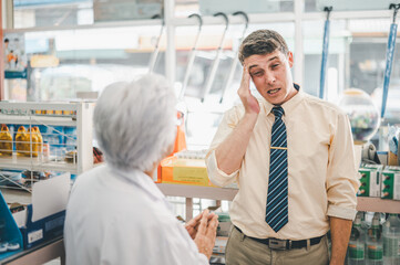 pharmacist is asking about a patient's condition in order to prescribe medication according to the patient's symptoms who come for prescription consultation in a modern pharmacy.