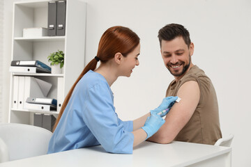 Obraz premium Doctor giving hepatitis vaccine to patient in clinic