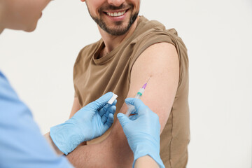 Fototapeta premium Doctor giving hepatitis vaccine to patient on white background, closeup