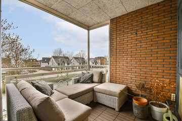 an outdoor living room with brick walls and floor to ceiling windows looking out onto the canal in...