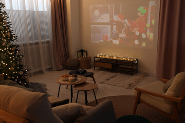 Video projector with Christmas movie in cosy room. Winter holidays atmosphere