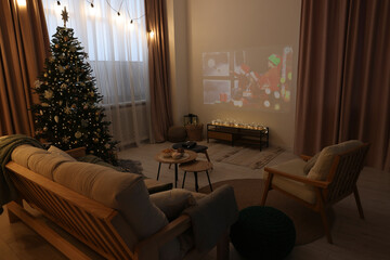 Video projector with Christmas movie in cosy room. Winter holidays atmosphere
