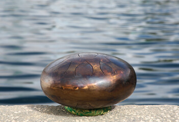 Steel tongue drum near sea. Percussion musical instrument