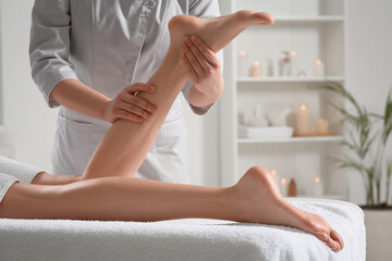 Woman receiving leg massage in spa salon, closeup