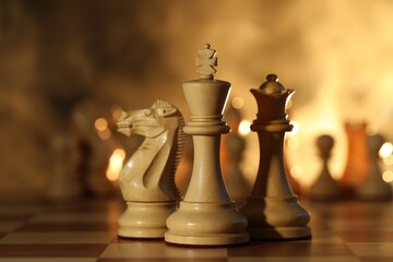 Wooden king, queen and knight on chessboard, closeup