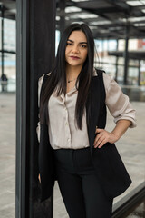Obraz premium wearing a vest, blouse and elegant office clothes a young latin woman with straight hair, workplace and lifestyle, business person portrait
