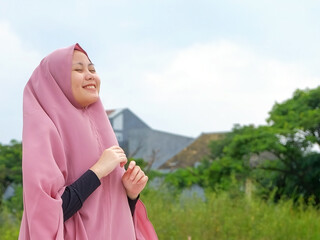 Asian Muslim woman, embracing nature's beauty. Serene tranquility meets cultural diversity in this captivating moment.