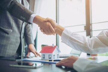Estate agent shaking hands with customer after contract signature to the customer, mortgage loan agreement Making lease and buy and sell house And contract home insurance mortgage loan concept