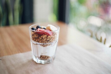 Granola and yogurt parfait cup with bananas, fruits, strawberries, blueberries