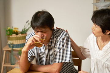 自宅で落ち込む中年男性