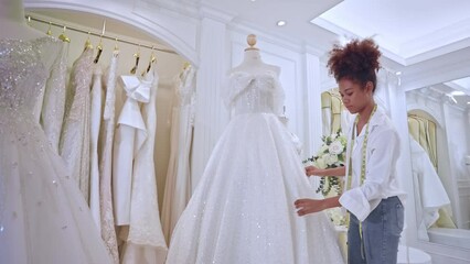 African American female designer designing bridal gown in wedding studio.