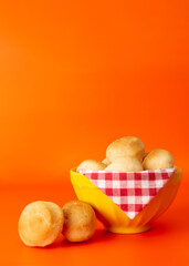 Cheese bread (Brazilian pao de queijo mineiro), front view, focused, isolated, on a bowl, vertical