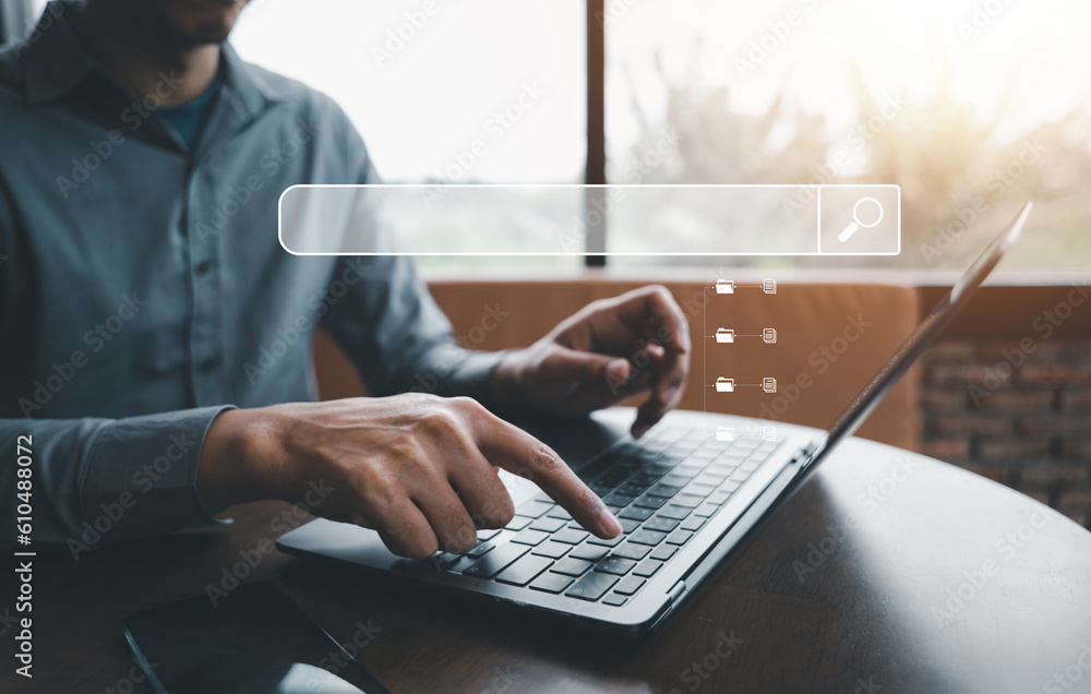 Poster a businessman using a laptop in his office, searching and browsing the internet for information with